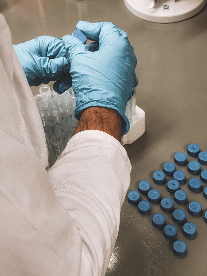 Researcher in a lab coat arranging samples in a laboratory setting.